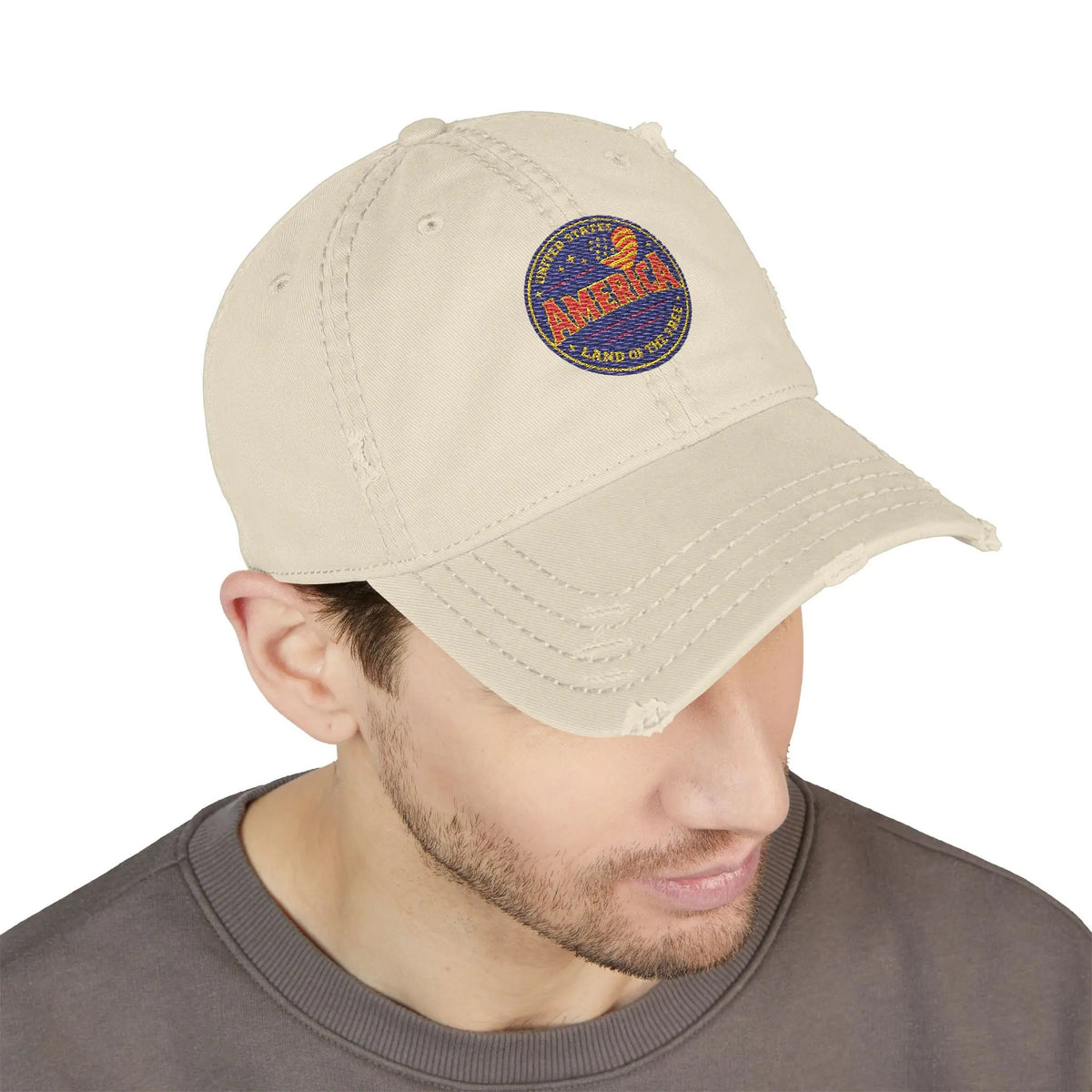 Distressed tan baseball cap with "America Land of the Free" circular patch.