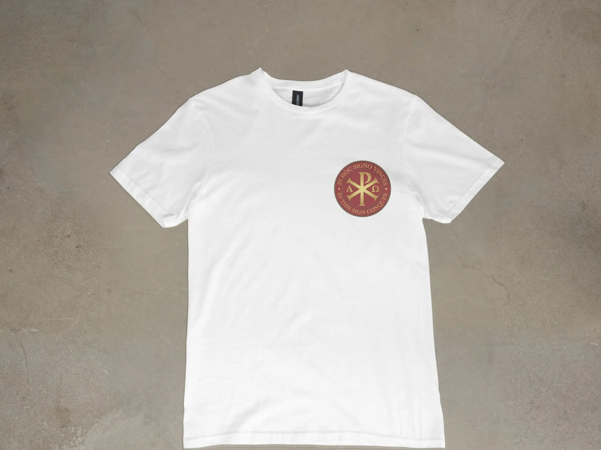 White t-shirt with a circular emblem featuring the Chi Rho symbol and Latin text "In hoc signo vinces."