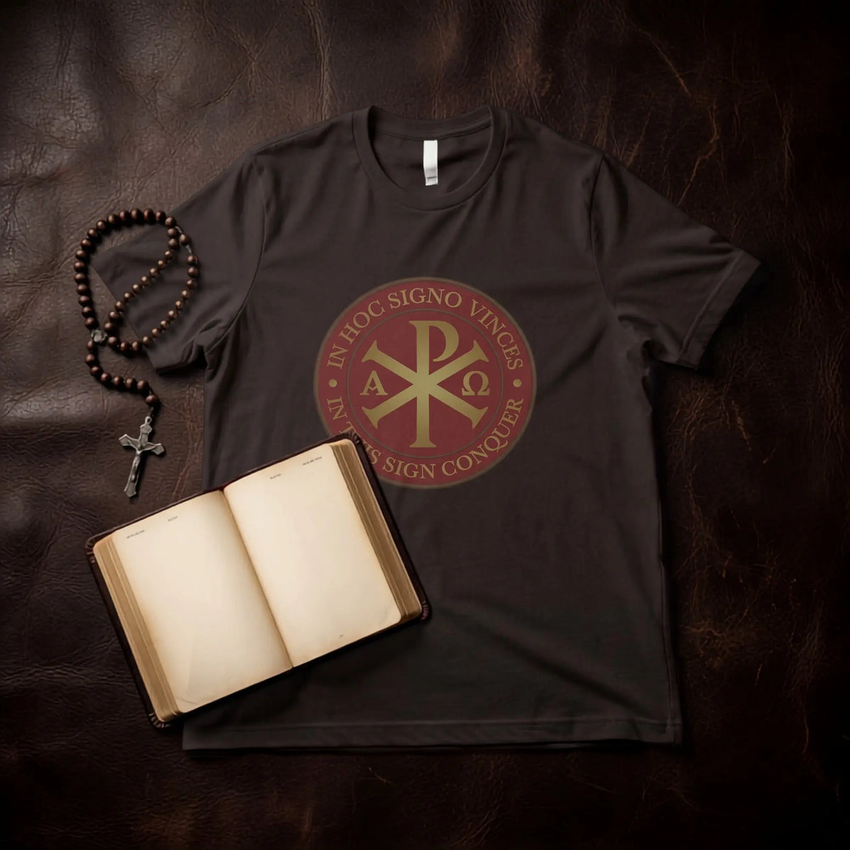 Dark t-shirt with Chi Rho symbol and Latin inscription, rosary, and open book.